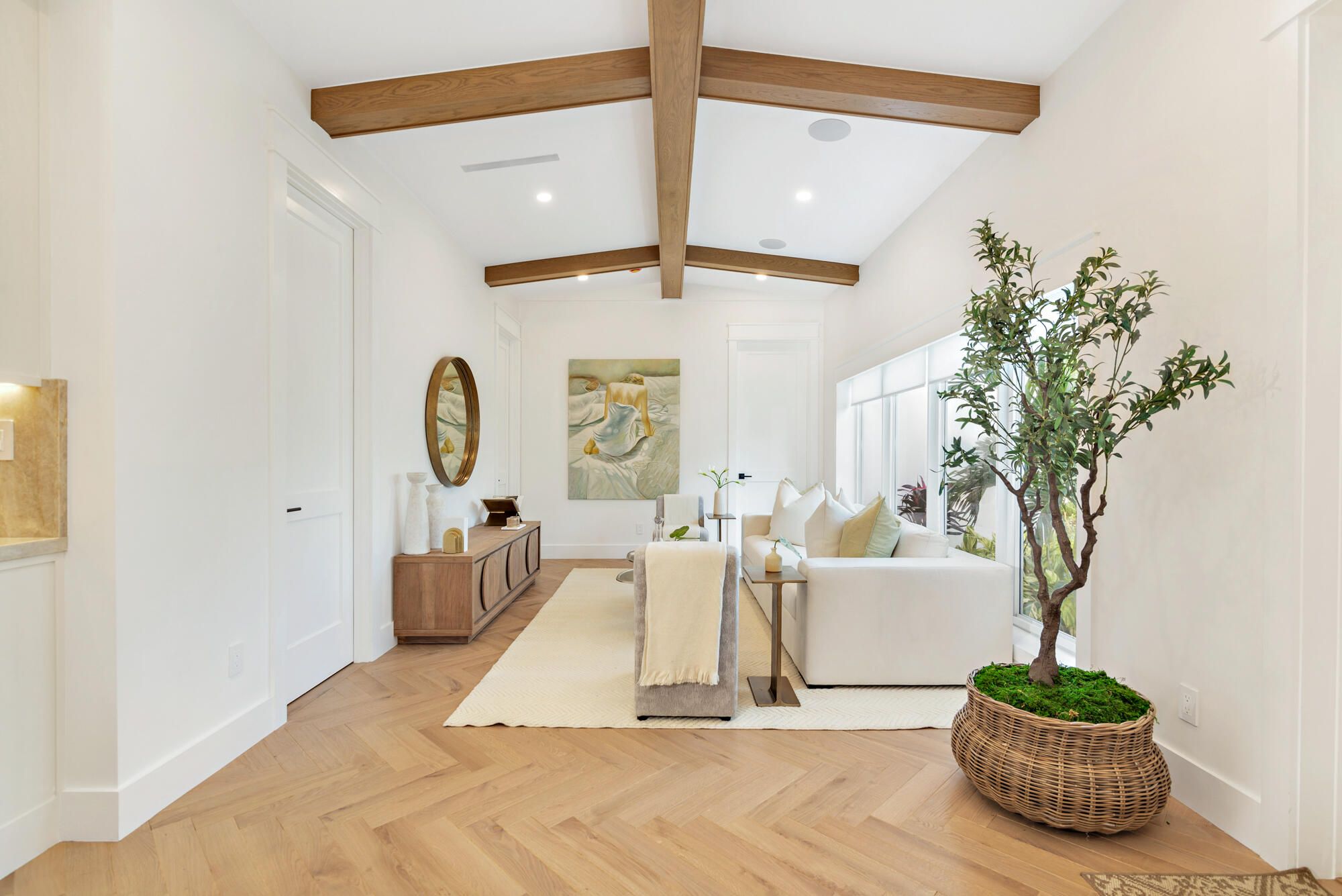 Stained wood beams crossing a white vaulted living room ceiling, West Palm Beach