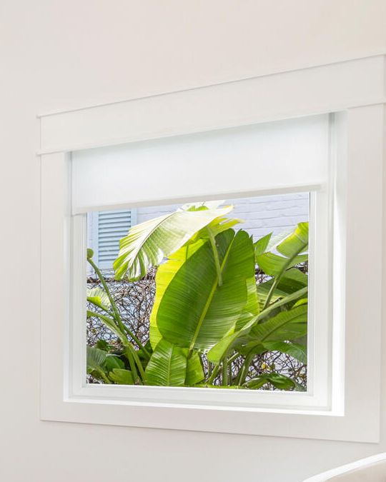 Custom white window casing around a bedroom window, West Palm Beach