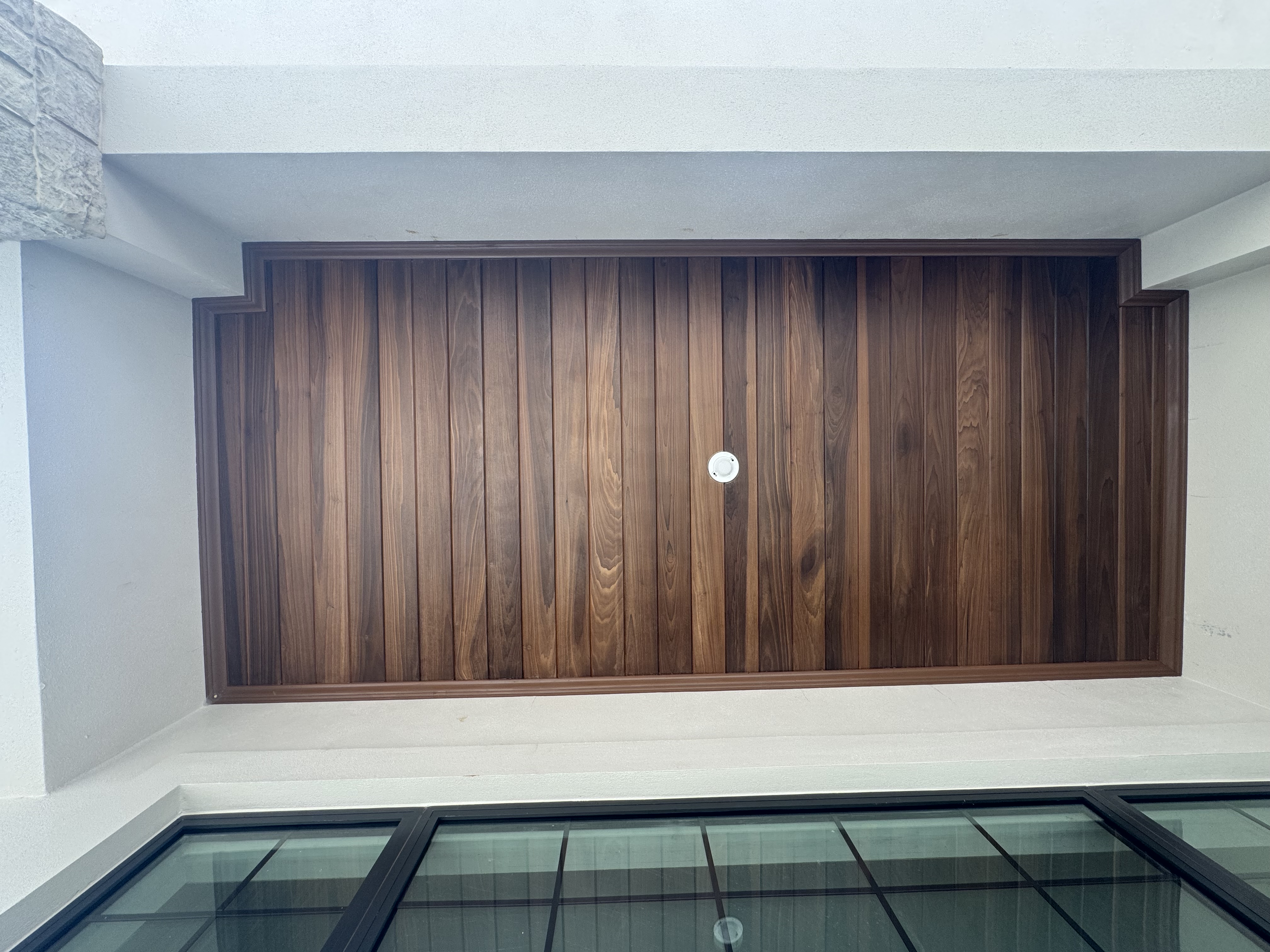 Custom wood slat millwork recessed into white plaster