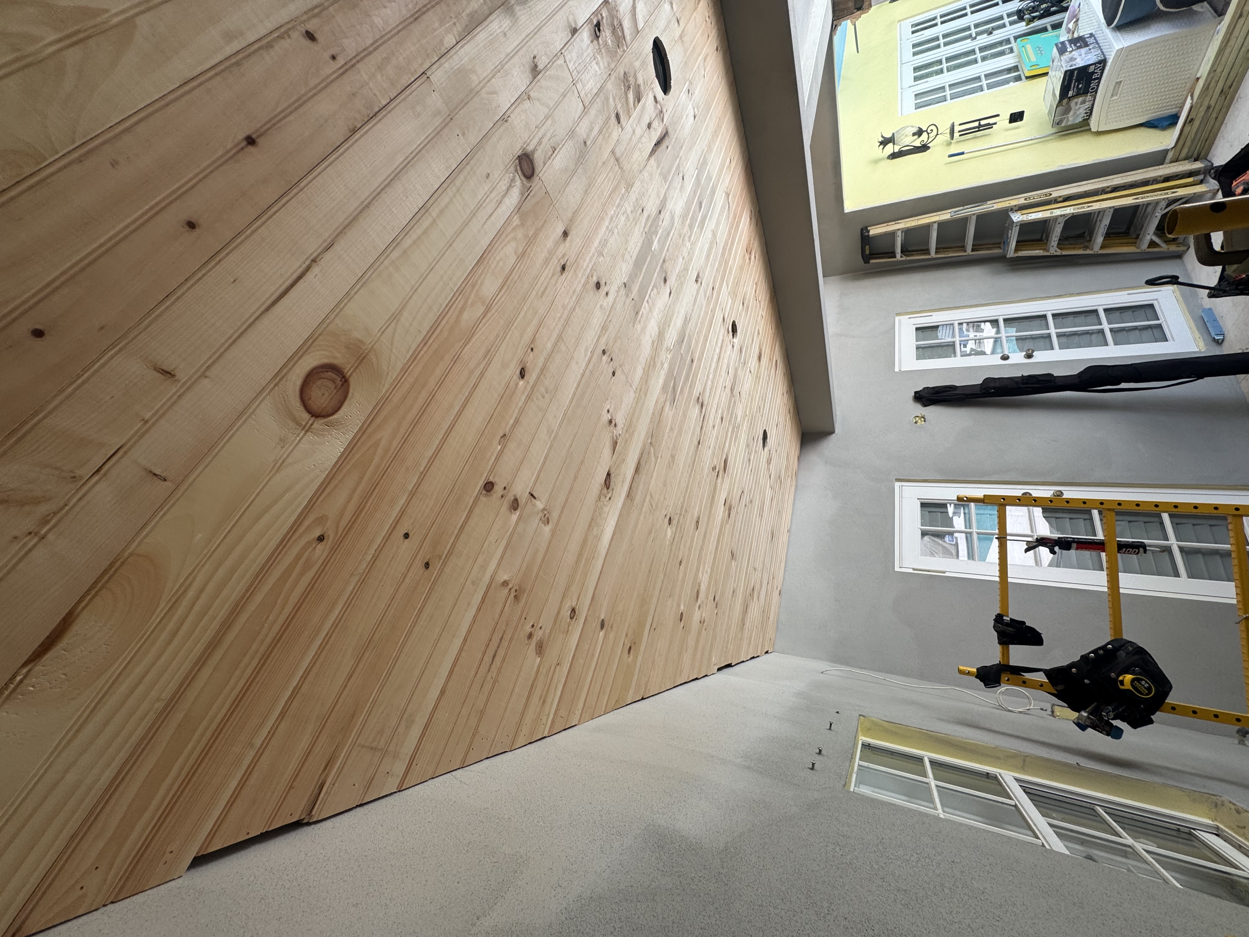 Tongue-and-groove patio ceiling in natural stock, with recessed-light cutouts